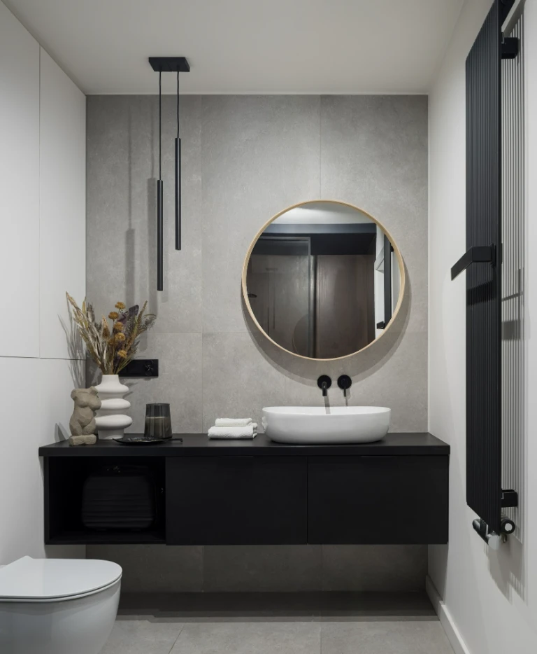 Łazienka w&nbsp;ciemnym stylu z&nbsp;okrągłym lustrem
